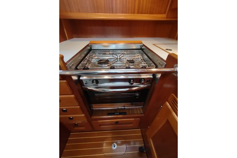 Slide: The Image of Galley kitchen in 2005 Hallberg-Rassy 43 yacht with stove and wooden cabinetry. - 50
