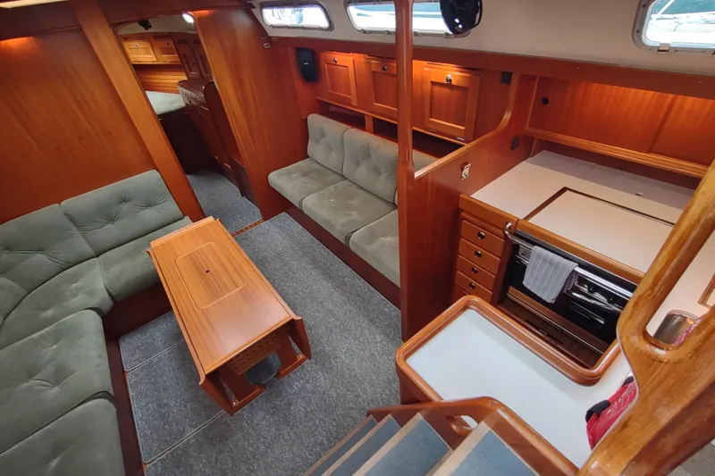 Slide: The Image of Luxurious 2005 Hallberg-Rassy 43 yacht interior with elegant wood finish and cozy seating area. - 36