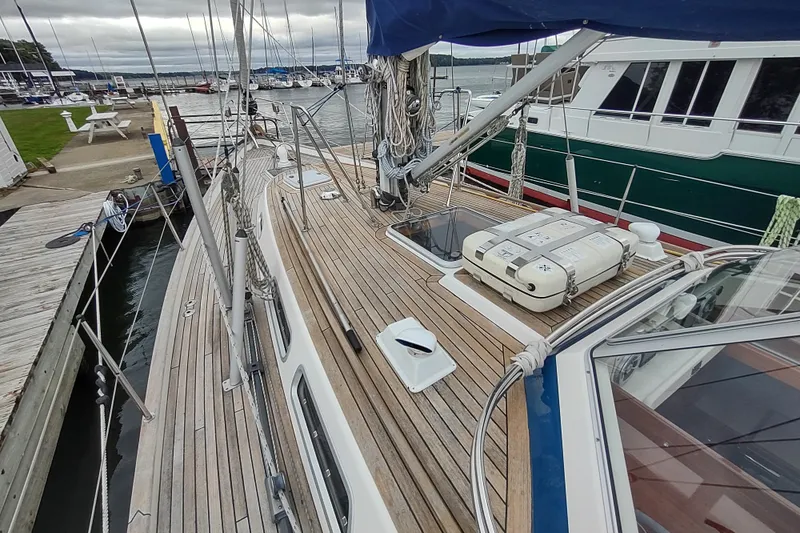 Slide: The Image of 2005 Hallberg-Rassy 43 sailboat docked, showcasing teak deck and rigging. - 16