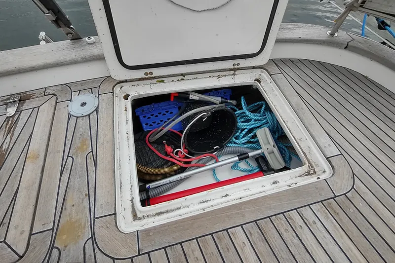 Slide: The Image of Open storage compartment on 2005 Hallberg-Rassy 43 sailboat deck with ropes and equipment. - 24