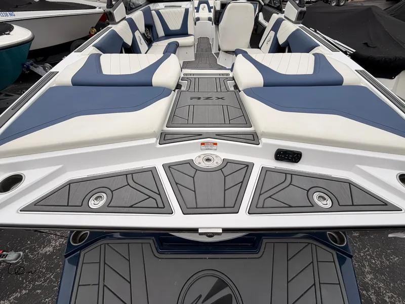 Slide: The Image of The image shows the deck of a 2021 Tigé 22RZX boat with blue and white upholstery. - 9