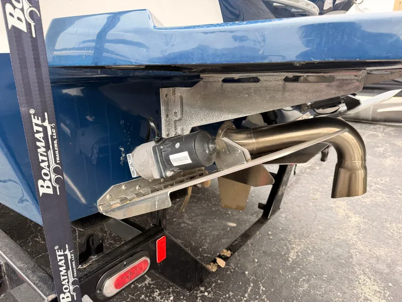 Slide: The Image of The image shows the rear of a blue Tigé 22RZX boat with an exhaust pipe and trailer. - 5