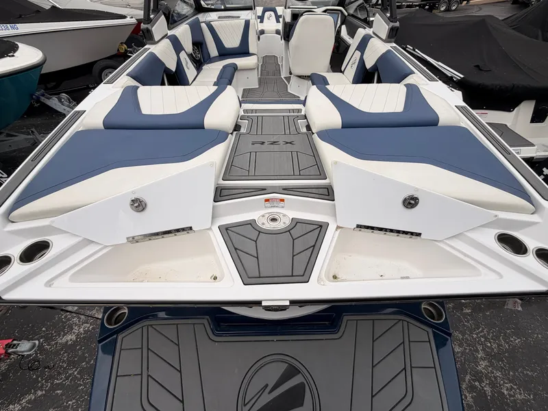 Slide: The Image of The image shows the stern of a 2021 Tigé 22RZX boat with blue and white upholstery. - 10