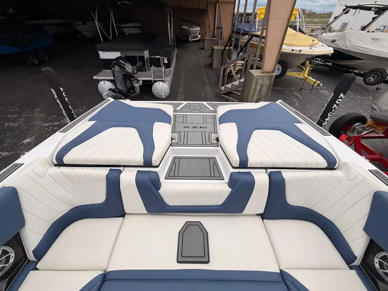 Slide: The Image of The image shows the stern of a 2021 Tigé 22RZX boat with blue and white upholstery. - 12