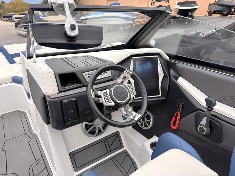 Slide: The Image of The image shows the cockpit of a 2021 Tigé 22RZX boat with a modern steering wheel and touchscreen. - 37