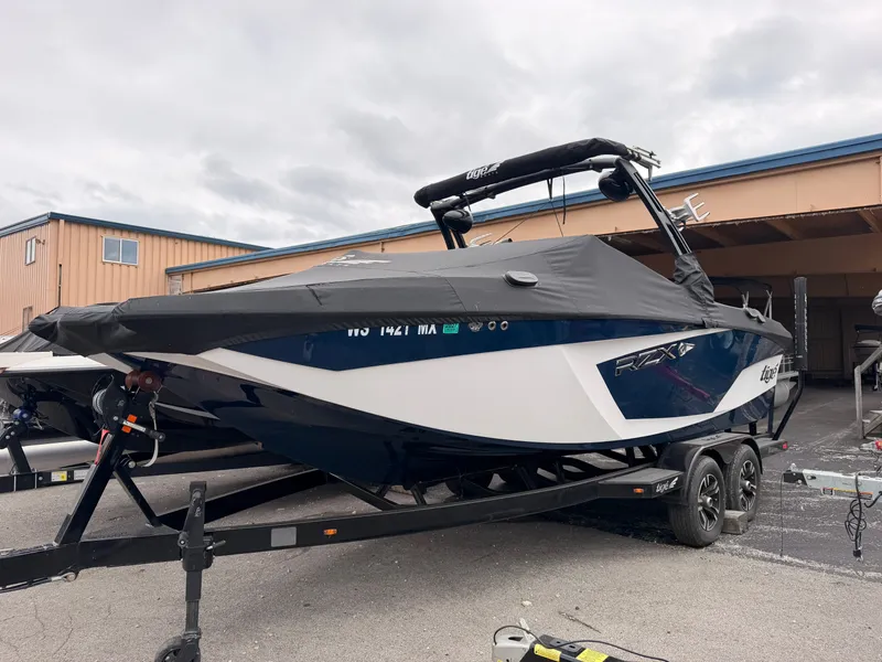 Slide: The Image of A 2021 Tigé 22RZX boat on a trailer, covered with a black tarp. - 2
