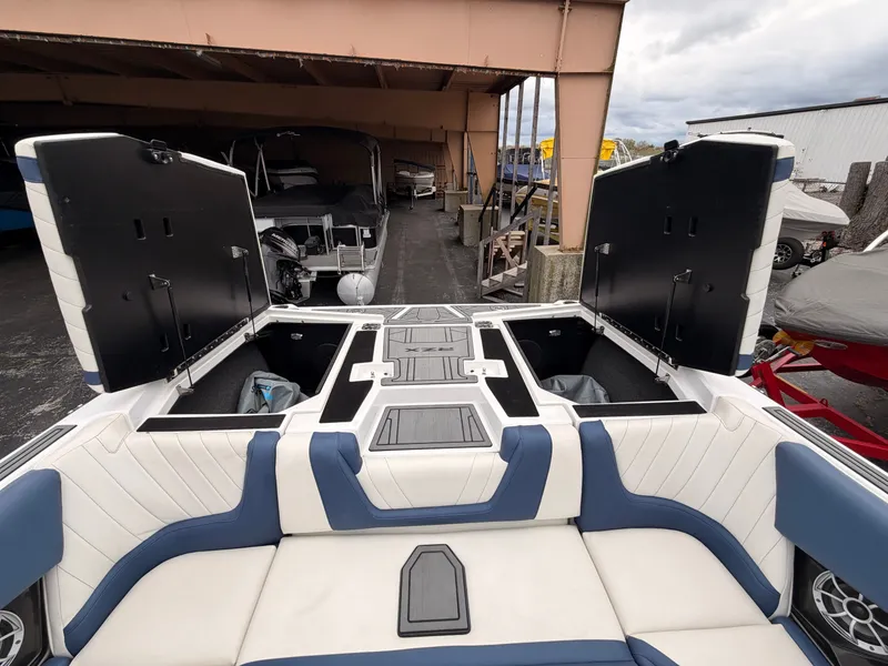 Slide: The Image of The image shows the rear of a 2021 Tigé 22RZX boat with open storage compartments. - 13