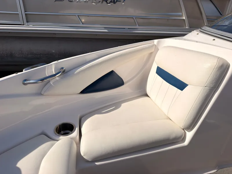 Slide: The Image of A white seat with blue accent in a boat, next to a cup holder. - 34