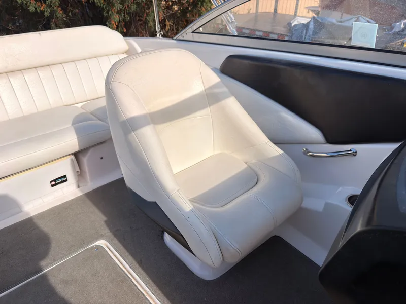 Slide: The Image of A white seat in a boat with gray carpet and black side paneling. - 16