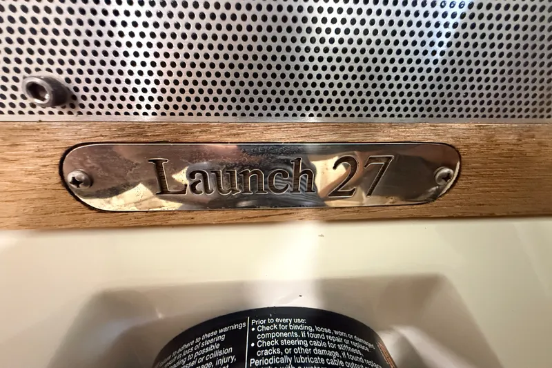 Slide: The Image of 2019 Chris-Craft Launch 27 nameplate on wood and metal background. - 22