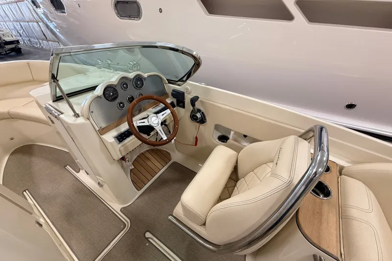 Slide: The Image of 2019 Chris-Craft Launch 27 boat interior with steering wheel and beige seating. - 14