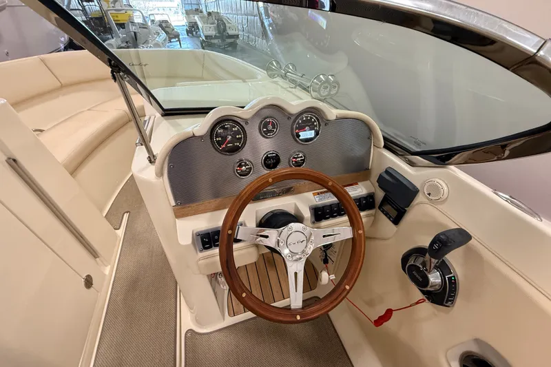 Slide: The Image of 2019 Chris-Craft Launch 27 boat dashboard with wooden steering wheel and modern controls. - 17