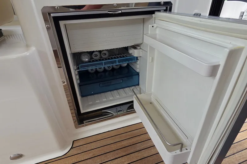 Slide: The Image of Open mini fridge on Bavaria 360 Sport HT yacht, showcasing interior storage and beverages. - 14