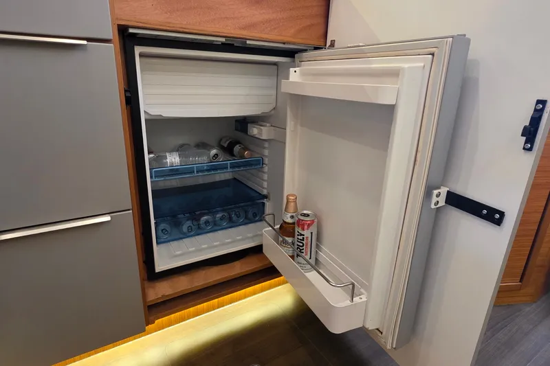 Slide: The Image of Open fridge in Bavaria 360 Sport HT yacht, stocked with drinks and water bottles. - 29