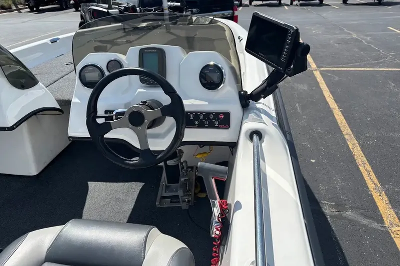 Slide: The Image of 2004 Bass Cat Pantera Classic boat dashboard with steering wheel and electronic display. - 7