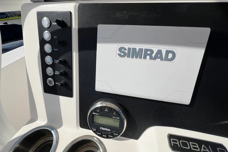 Slide: The Image of 2024 Robalo R200 Center Console dashboard with Simrad display and Clarion audio system. - 12