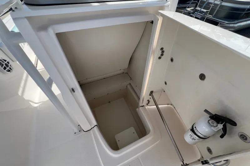 Slide: The Image of 2024 Robalo R200 Center Console storage compartment with fire extinguisher. - 18