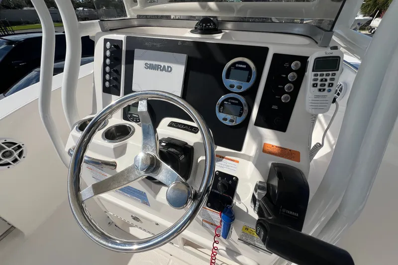 Slide: The Image of 2024 Robalo R200 Center Console boat dashboard with steering wheel and navigation controls. - 10