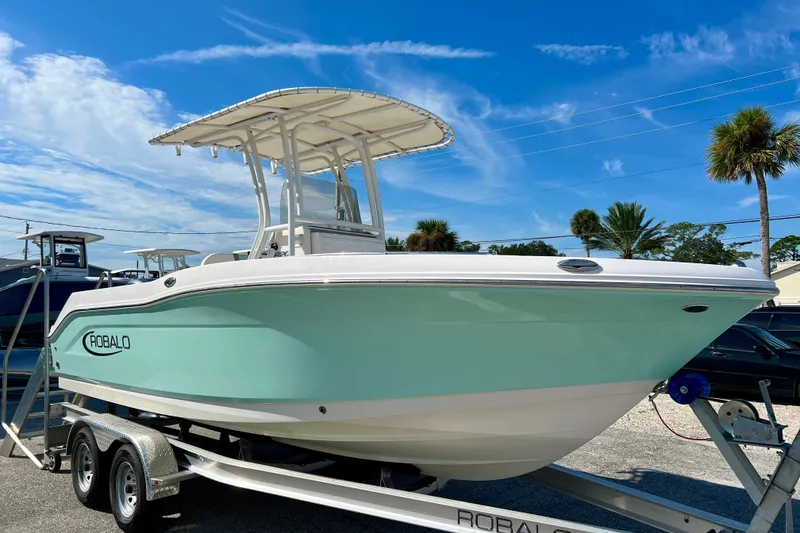 Slide: The Image of 2024 Robalo R200 Center Console boat on trailer under clear blue sky. - 2