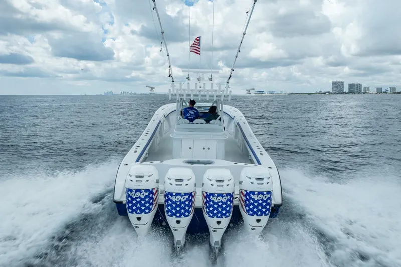 Slide: The Image of 2023 Yellowfin 39 Offshore boat cruising with four powerful engines, American flag design. - 30