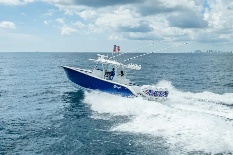 Slide: The Image of 2023 Yellowfin 39 Offshore boat cruising on open ocean with American flag. - 26