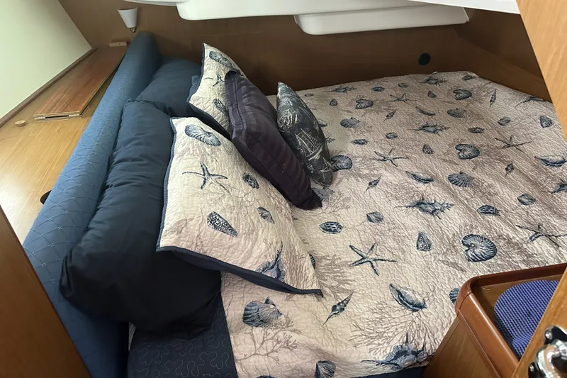 Slide: The Image of Cozy cabin interior of 2007 Jeanneau Sun Odyssey 39 DS with nautical-themed bedding. - 23