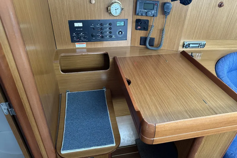 Slide: The Image of 2007 Jeanneau Sun Odyssey 39 DS navigation station with control panel and communication equipment. - 25