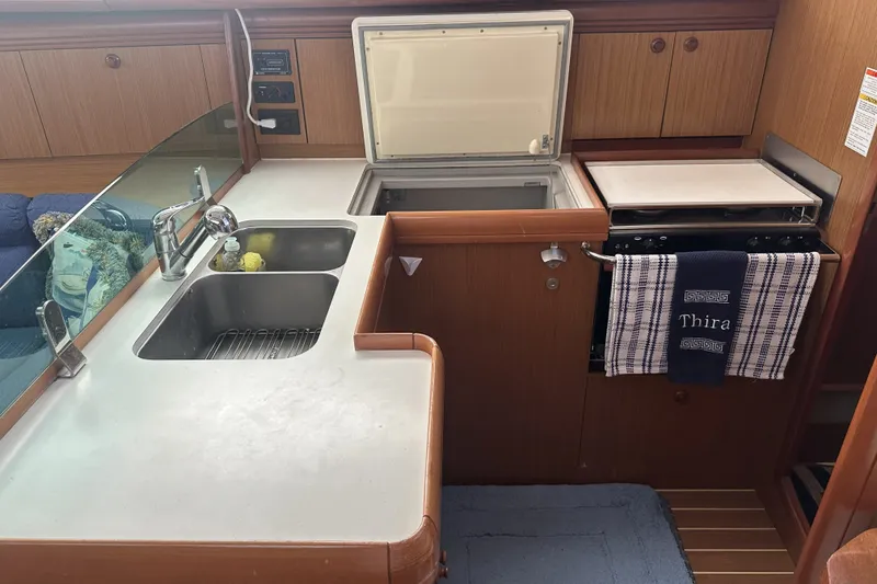 Slide: The Image of 2007 Jeanneau Sun Odyssey 39 DS yacht kitchen with sink, stove, and towel. - 19