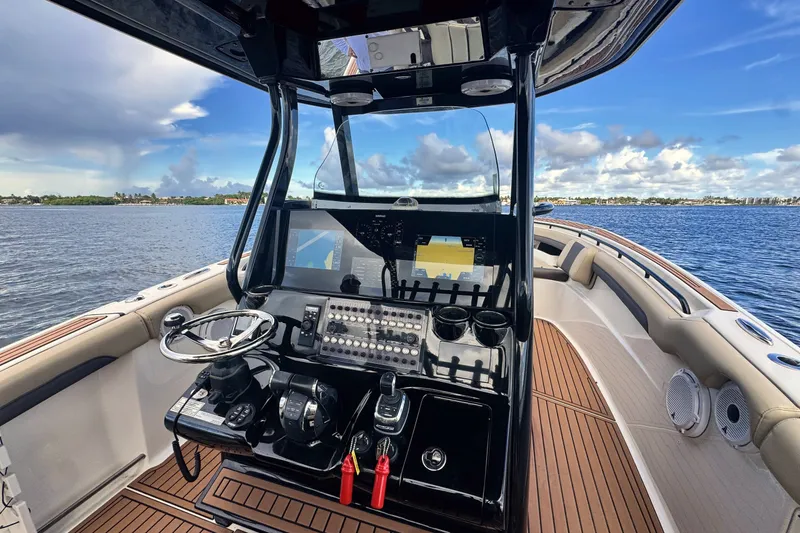 Slide: The Image of 2019 Tidewater 320 CC Adventure boat cockpit with advanced navigation system on open water. - 23