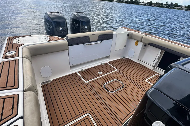 Slide: The Image of 2019 Tidewater 320 CC Adventure boat with spacious deck and twin engines on a calm lake. - 18