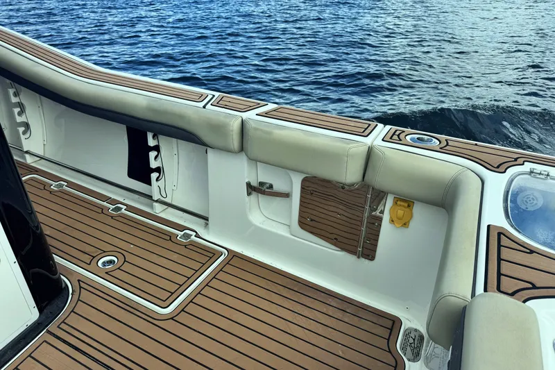 Slide: The Image of 2019 Tidewater 320 CC Adventure boat interior with cushioned seating and teak flooring. - 16