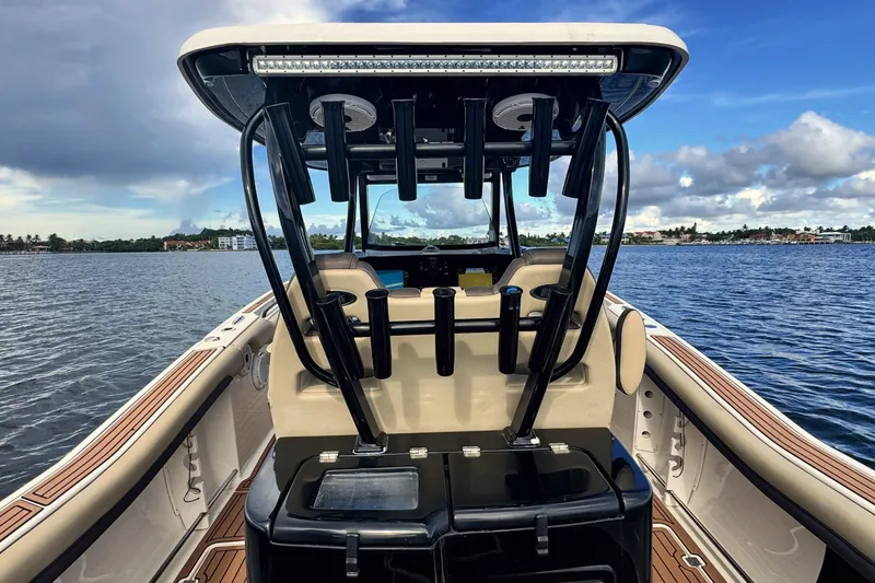 Slide: The Image of 2019 Tidewater 320 CC Adventure boat on calm water, showcasing sleek design and spacious deck. - 29