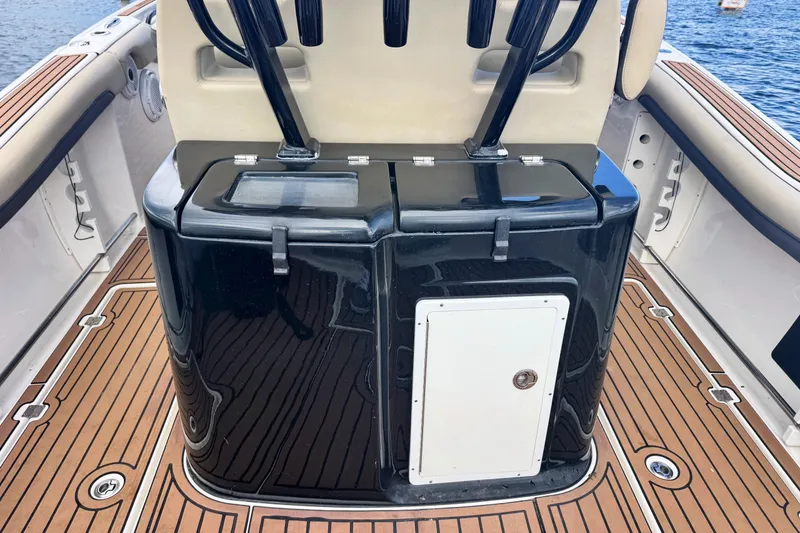 Slide: The Image of 2019 Tidewater 320 CC Adventure boat interior with sleek black console and wood-patterned flooring. - 27