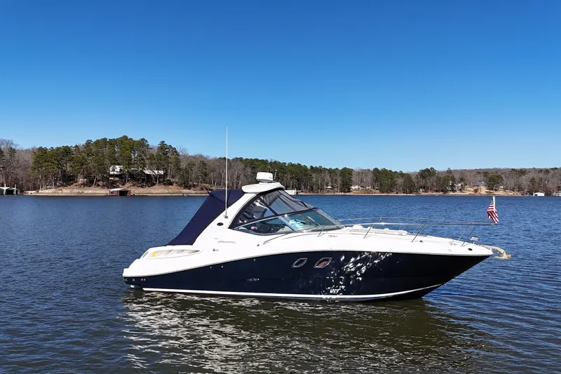 The Image of 2007 Sea Ray Sundancer 310 yacht on a serene lake with forested shoreline. - 0