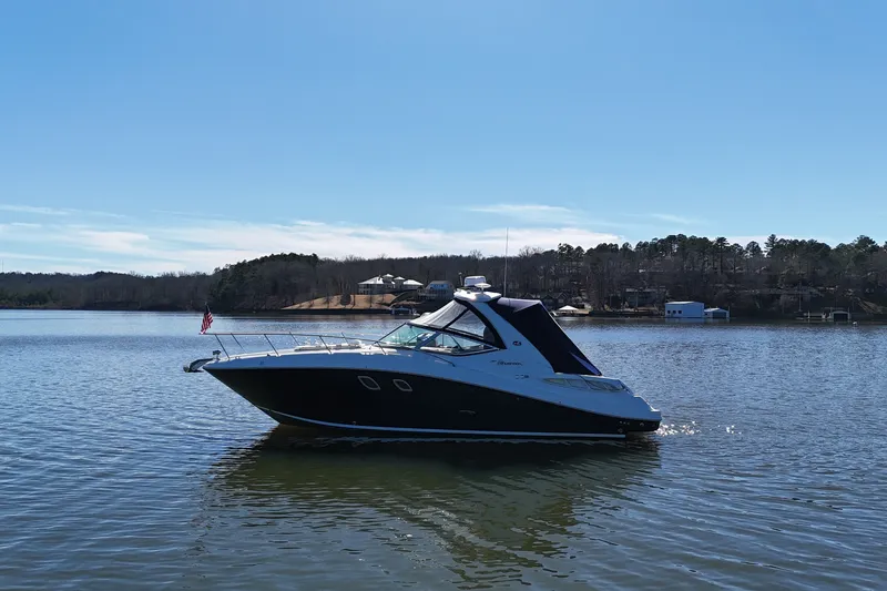 Slide: The Image of 2007 Sea Ray Sundancer 310 yacht on a serene lake with clear blue skies. - 6