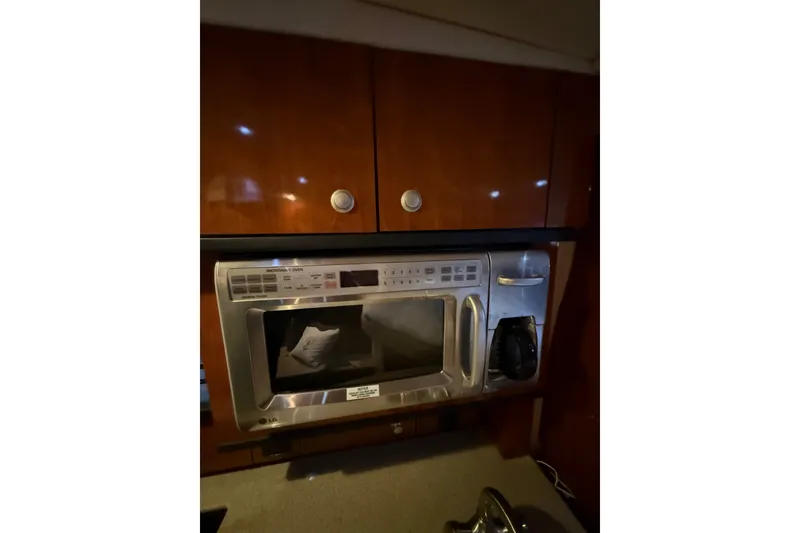 Slide: The Image of 2007 Sea Ray Sundancer 310 galley with microwave oven and wooden cabinetry. - 27
