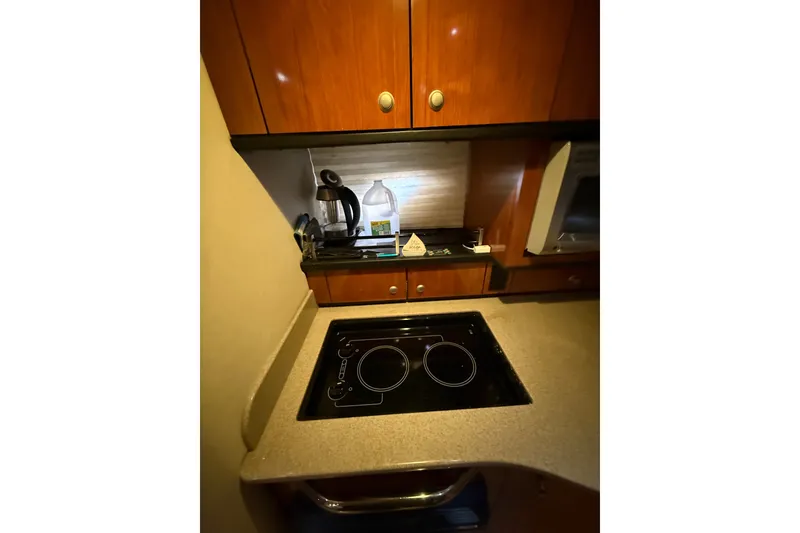 Slide: The Image of 2007 Sea Ray Sundancer 310 kitchen with stove, wooden cabinets, and appliances. - 26