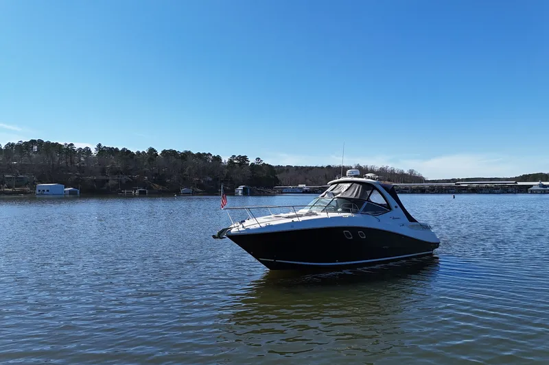 Slide: The Image of 2007 Sea Ray Sundancer 310 cruising on a serene lake under a clear blue sky. - 7