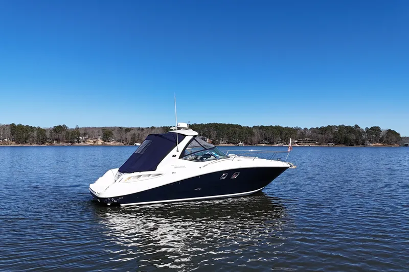 Slide: The Image of 2007 Sea Ray Sundancer 310 yacht on a calm lake under clear blue skies. - 12