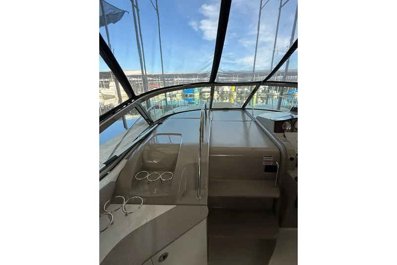 Slide: The Image of 2007 Sea Ray Sundancer 310 cockpit with clear canopy, showcasing helm and seating area. - 19