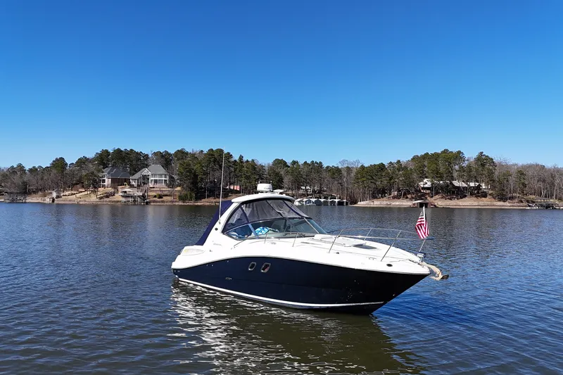 Slide: The Image of 2007 Sea Ray Sundancer 310 boat on a serene lake with clear blue sky. - 9