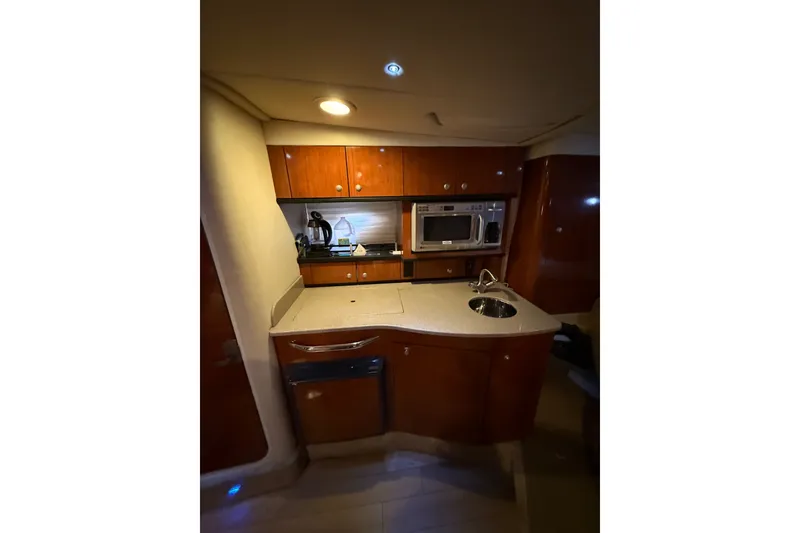 Slide: The Image of 2007 Sea Ray Sundancer 310 yacht interior kitchen with wooden cabinets and modern appliances. - 23