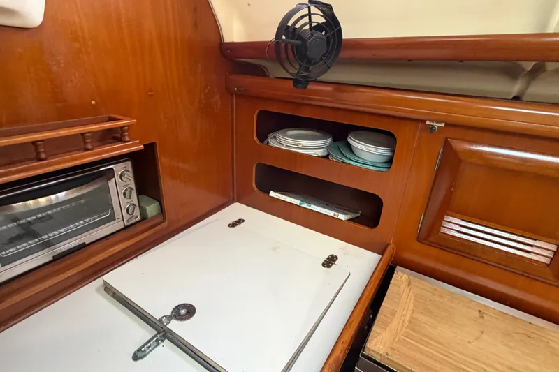 Slide: The Image of Interior of 2003 Beneteau Oceanis 393 yacht kitchen with wooden cabinetry and appliances. - 11