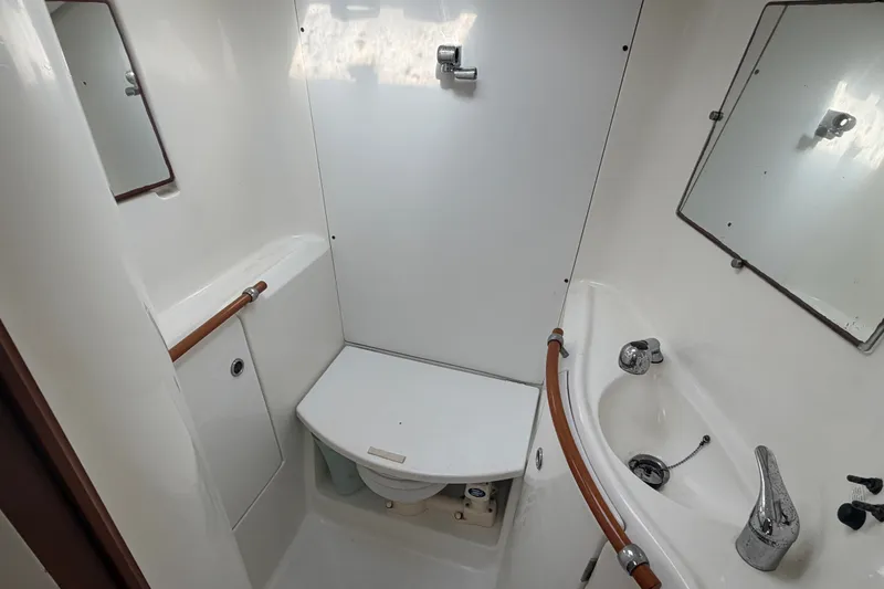 Slide: The Image of Bathroom interior of 2003 Beneteau Oceanis 393 yacht, featuring sink, toilet, and mirrors. - 24