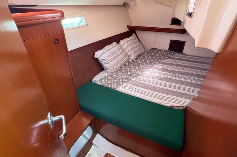 Slide: The Image of Cozy cabin interior of 2003 Beneteau Oceanis 393 sailboat with striped bedding. - 7