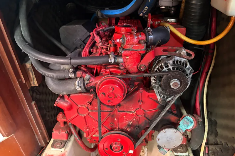 Slide: The Image of Red engine of a 2003 Beneteau Oceanis 393 sailboat, showcasing belts and hoses. - 33