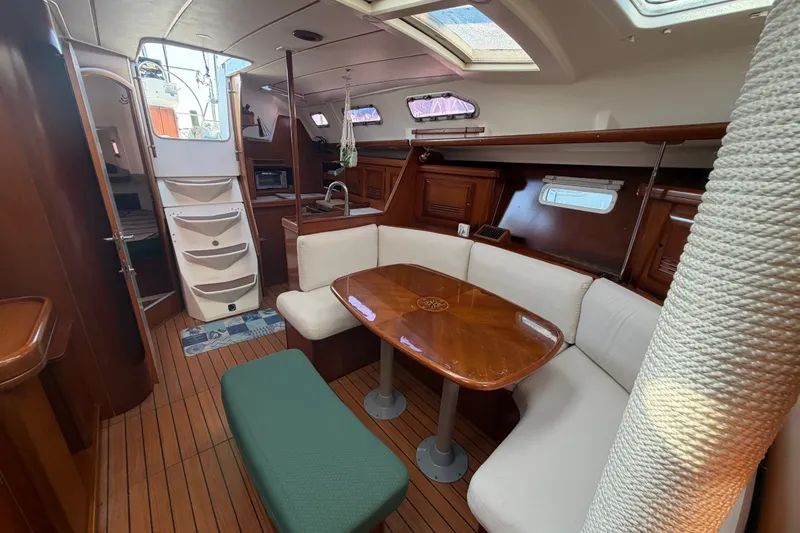 Slide: The Image of Interior of 2003 Beneteau Oceanis 393 yacht with cozy seating and wooden finishes. - 28