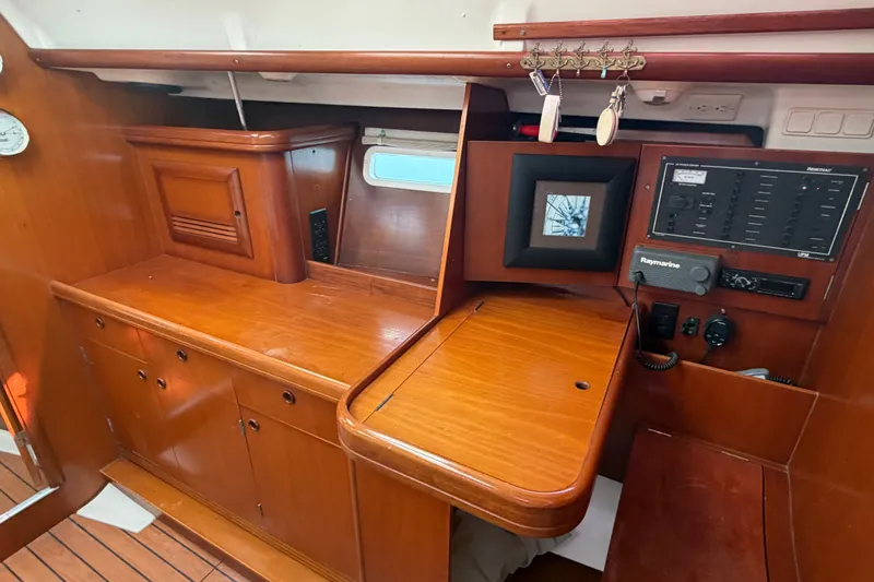 Slide: The Image of Interior of 2003 Beneteau Oceanis 393 sailboat with wooden cabinetry and navigation equipment. - 15