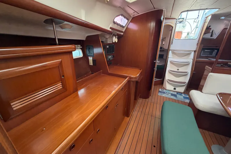 Slide: The Image of Interior of 2003 Beneteau Oceanis 393 sailboat, featuring elegant wood cabinetry and seating. - 27
