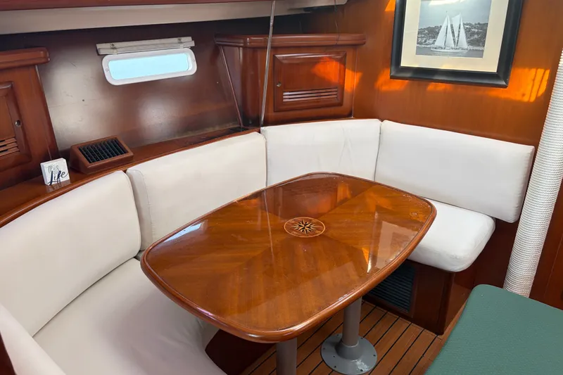 Slide: The Image of Cozy interior of 2003 Beneteau Oceanis 393 sailboat with wooden table and cushioned seating. - 35